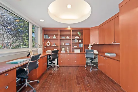 a living room with a bed and wooden floor