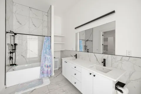 a bathroom with a tub sink and mirror