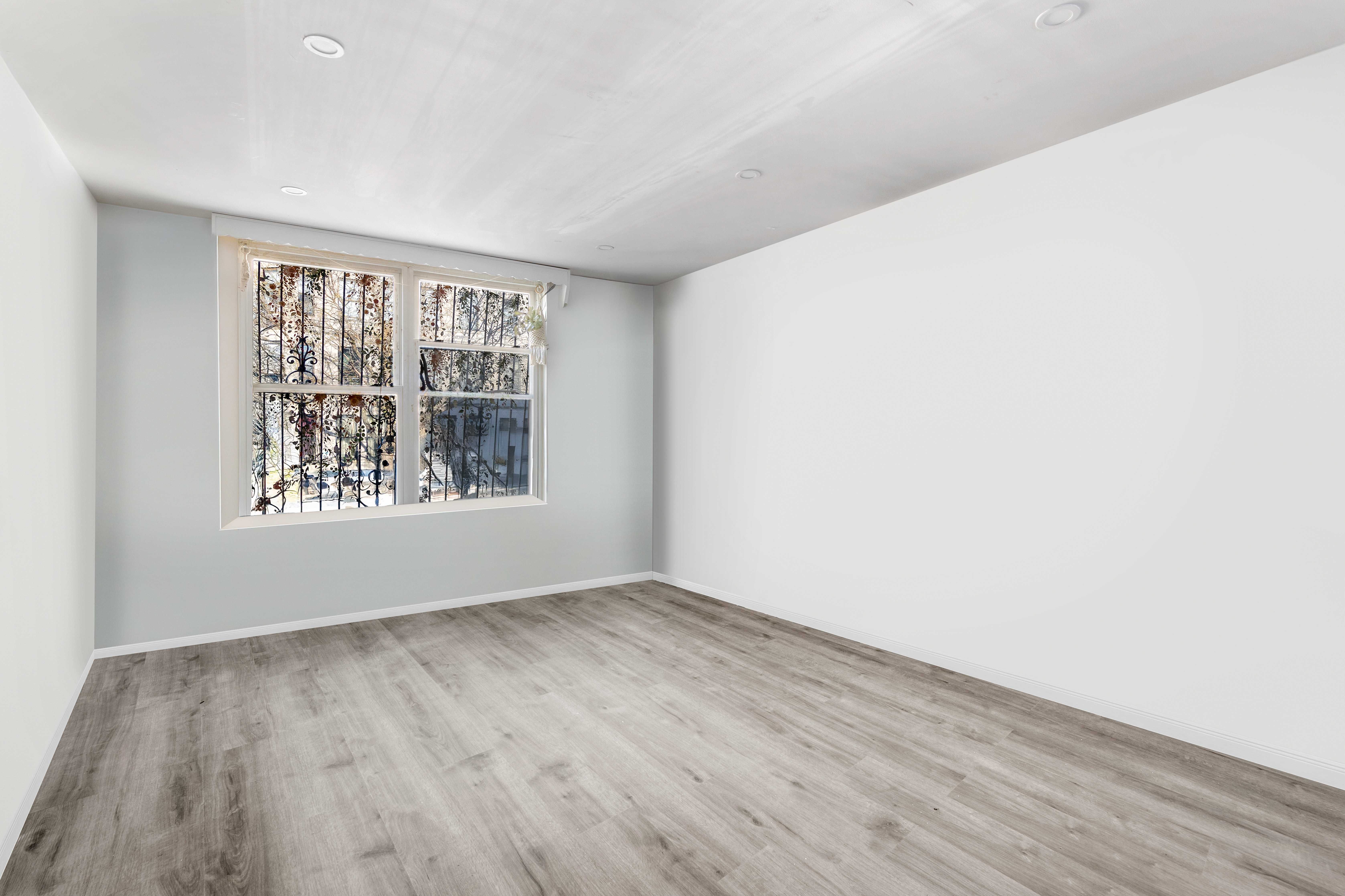 364 Chauncey Street Brooklyn, NY 11233 - Photo 7 of 17 a view of an empty room with wooden floor and a window