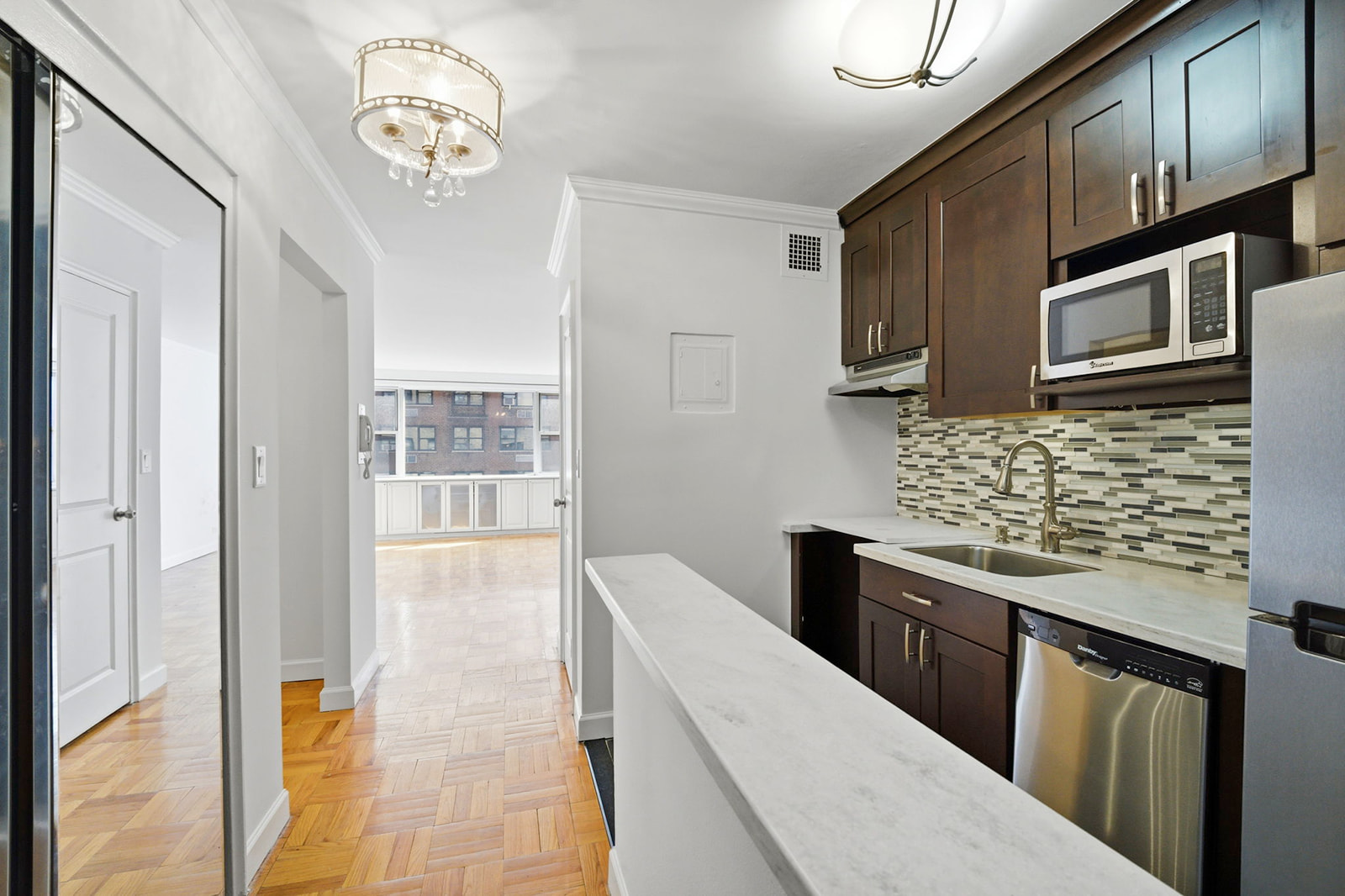 139 East 33rd Street, Unit 12DE Manhattan, NY 10016 - Photo 6 of 27 a kitchen with stainless steel appliances granite countertop a stove and cabinets