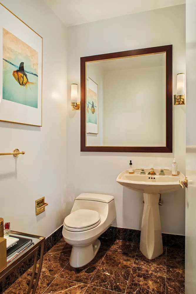 a bathroom with a toilet a sink and mirror