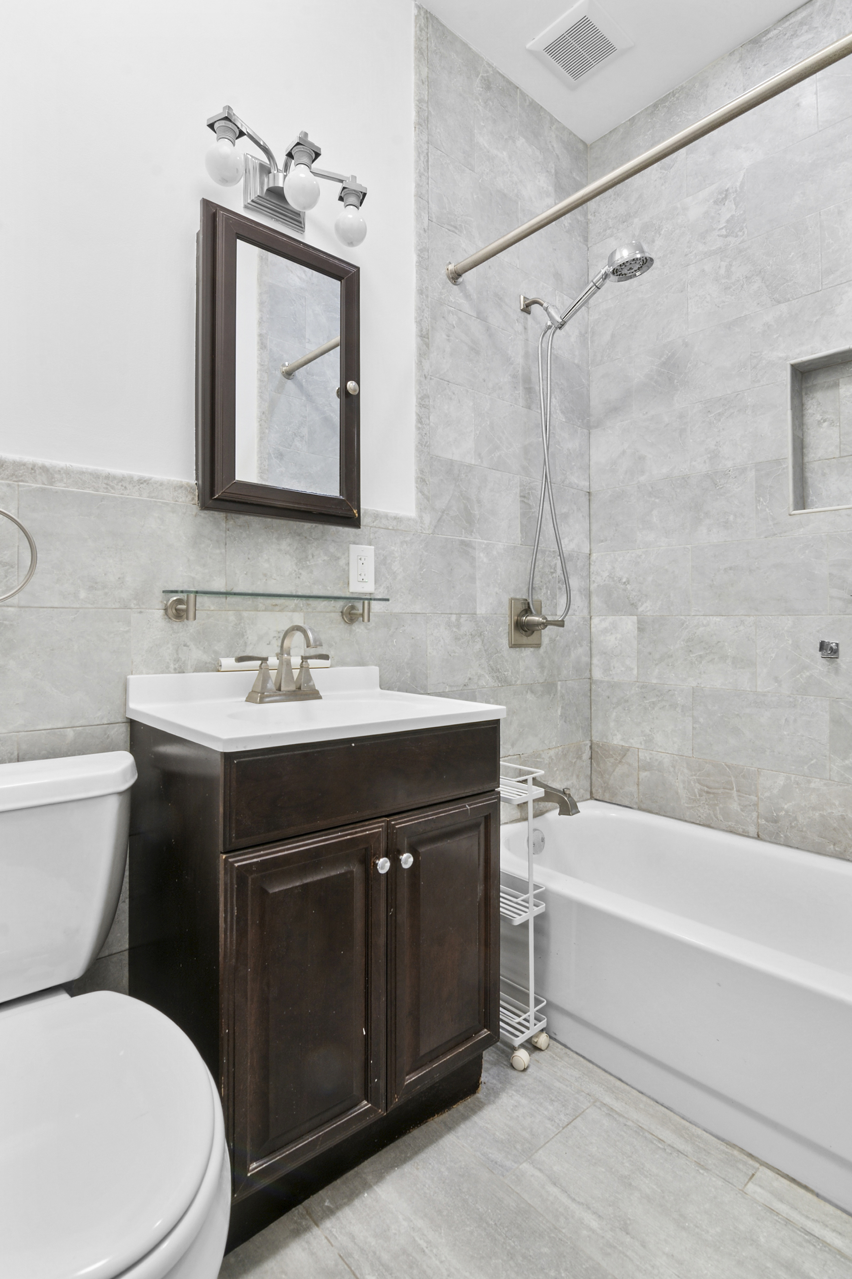 28 A Hart Street, Unit 3 Brooklyn, NY 11206 - Photo 4 of 6 a bathroom with a sink vanity mirror toilet and bathtub