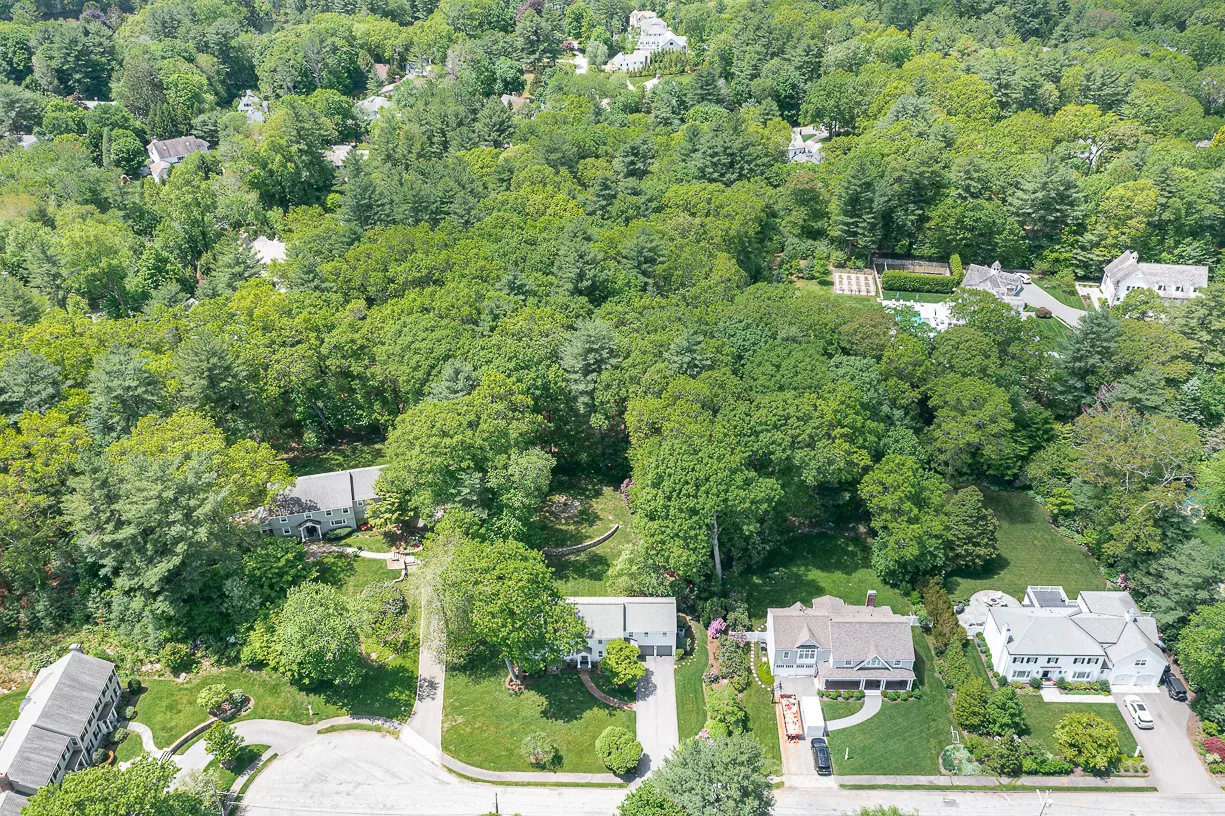 an aerial view of residential house with outdoor space and trees all around