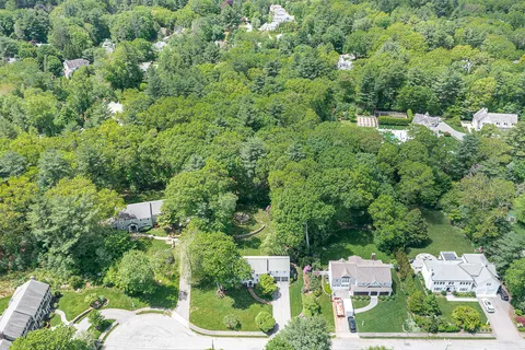 an aerial view of residential house with outdoor space and trees all around