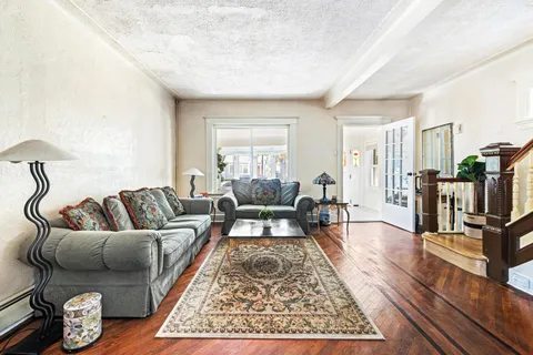 a living room with furniture wooden floor and a flat screen tv
