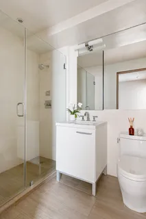 a bathroom with a sink a toilet and shower