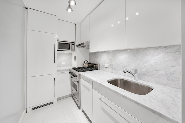 77 7th Avenue, Unit 9E Manhattan, NY 10011 - Photo 3 of 9 a kitchen that has a sink and a stove