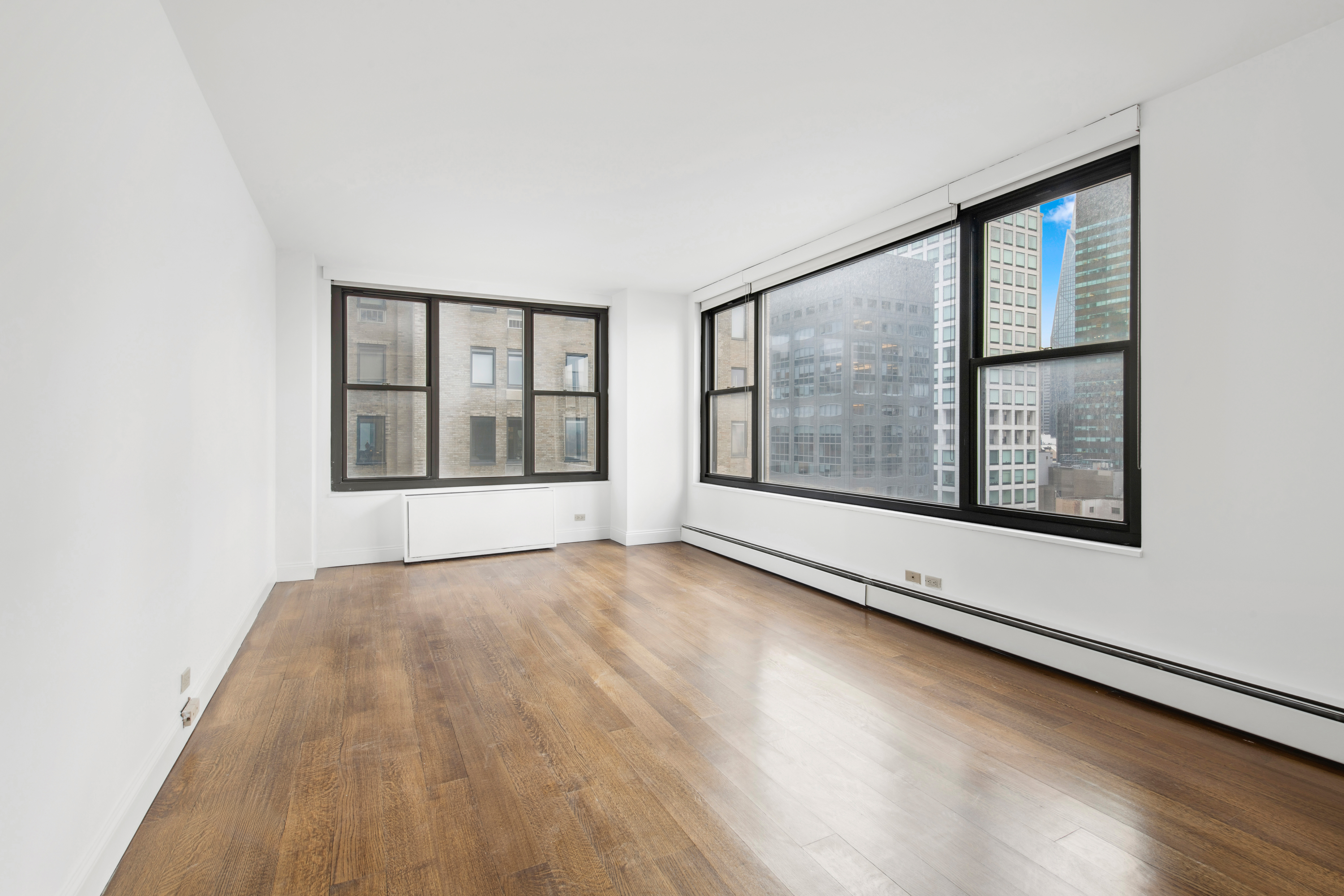 117 East 57th Street, Unit 35D Manhattan, NY 10022 - Photo 14 of 30 an empty room with wooden floor and windows