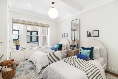 a bedroom with two beds and a large window