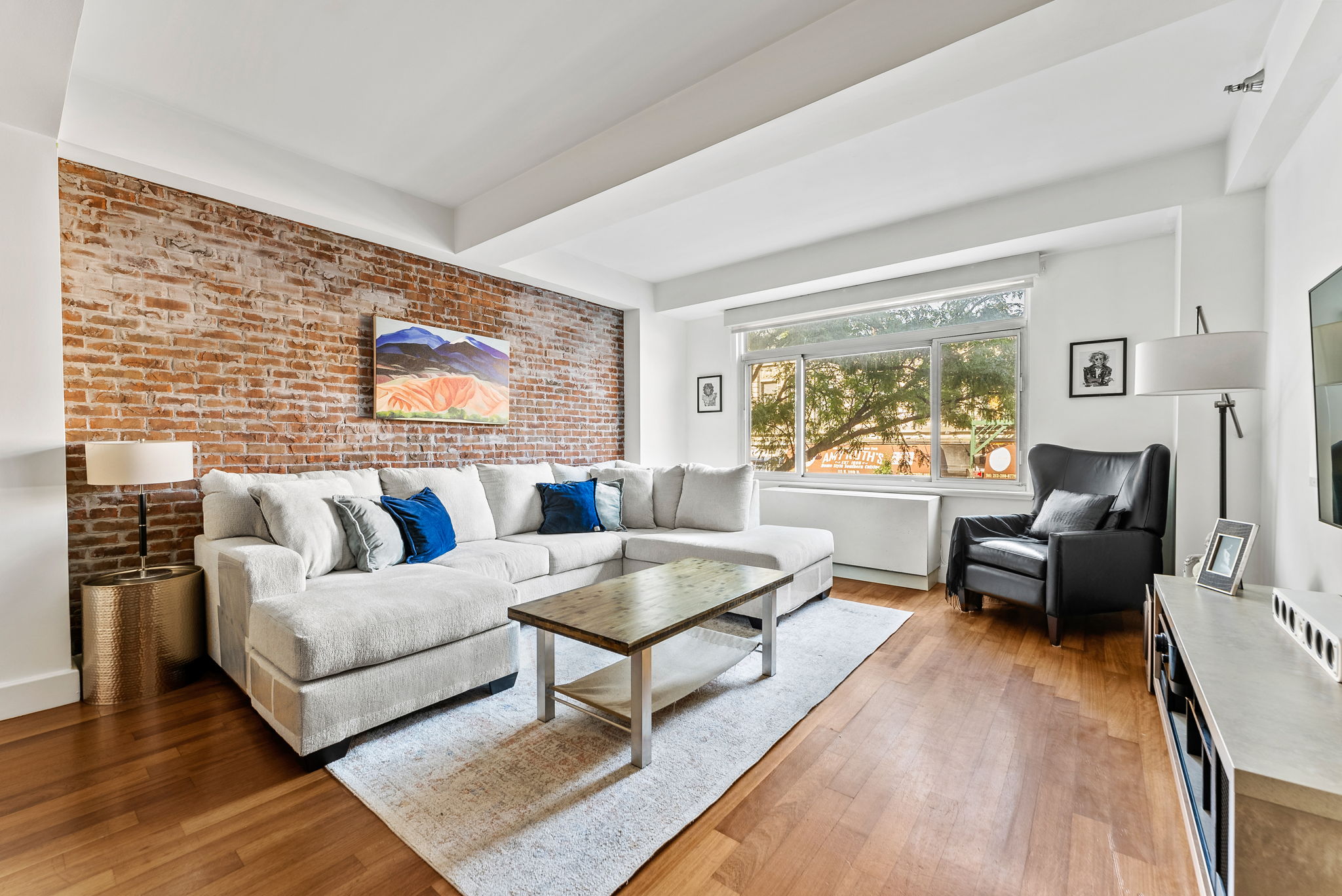 106 West 116th Street, Unit 2A Manhattan, NY 10026 - Photo 2 of 16 a living room with furniture and a flat screen tv