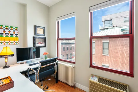 a living room with furniture a piano and a window