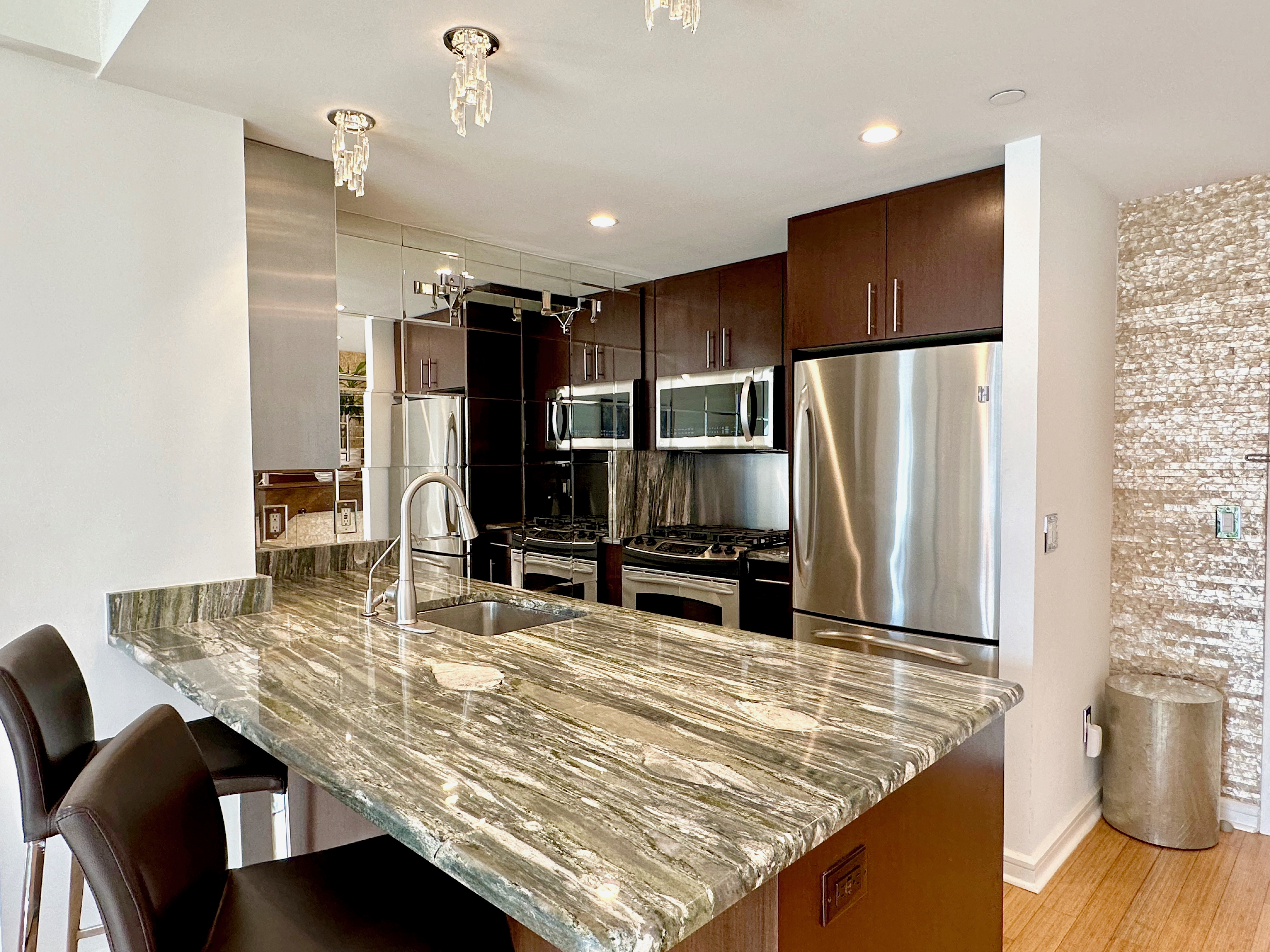 350 West 53rd Street, Unit PHA Manhattan, NY 10019 - Photo 7 of 35 a kitchen with stainless steel appliances a dining table chairs and refrigerator