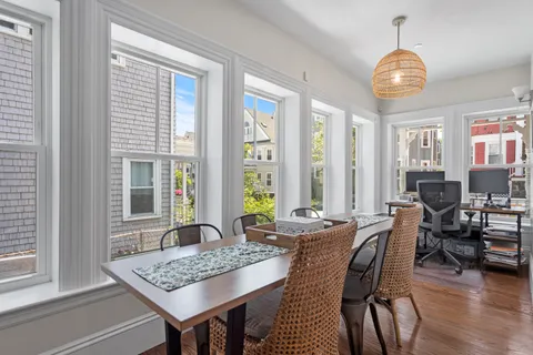 a view of a a dining room with furniture window and wooden floor