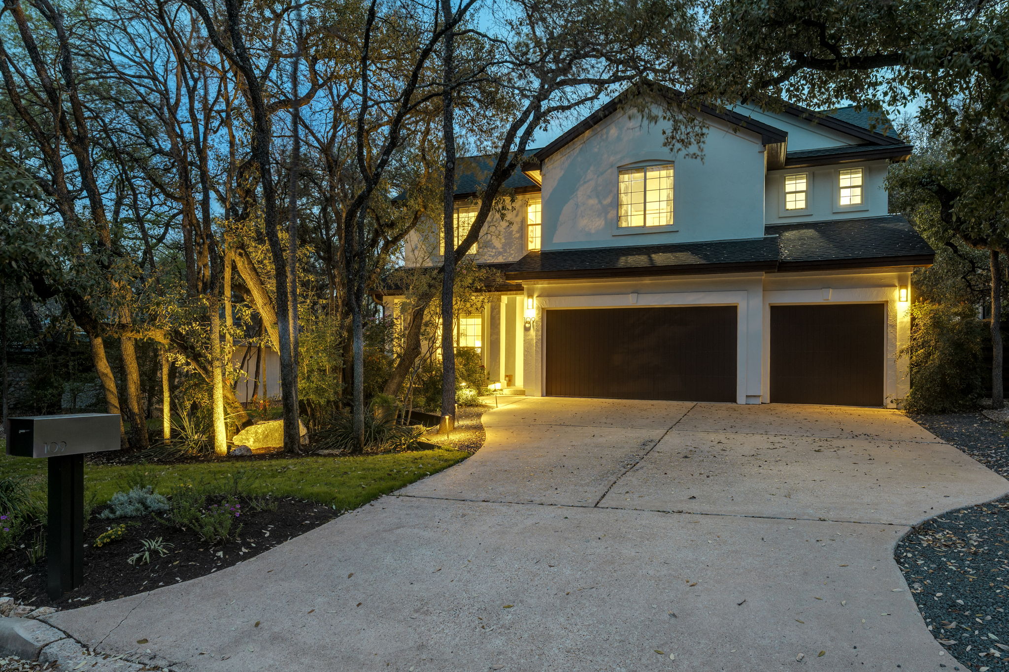 109 West Spring Drive Austin, TX 78746 - Photo 2 of 22 a front view of a house with a yard and garage