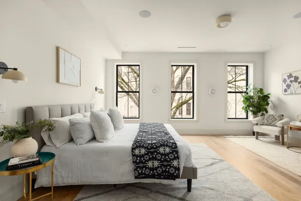 a bedroom with a large bed and windows