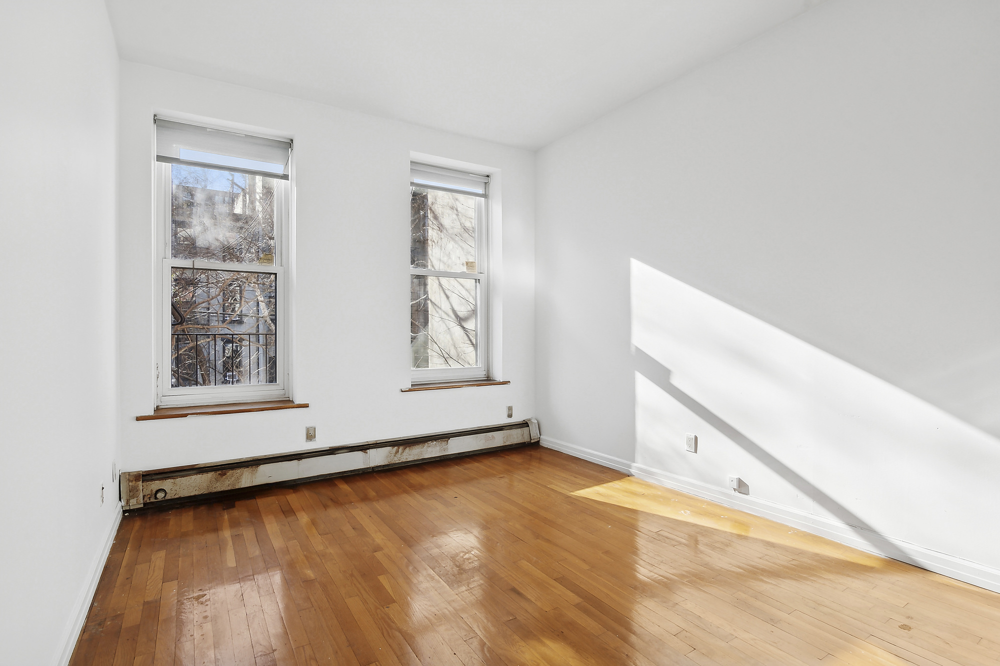 426 13th Street, Unit 2C Brooklyn, NY 11215 - Photo 6 of 13 a view of an empty room with window and wooden floor