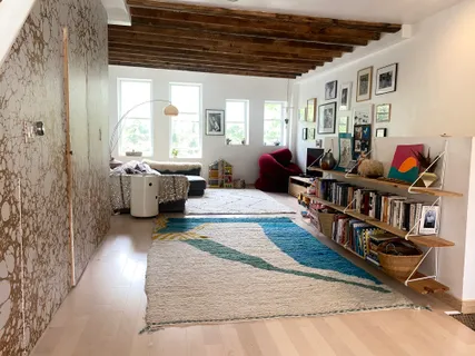 a living room with furniture and a book shelf