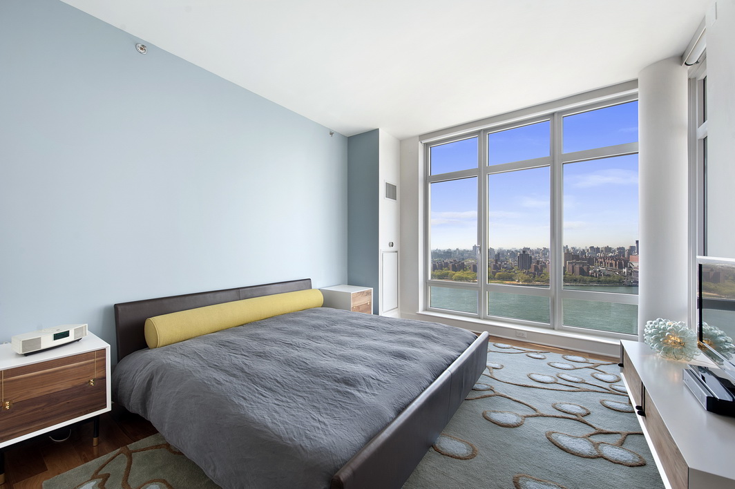 2 Northside Piers, Unit 27P Brooklyn, NY 11249 - Photo 9 of 19 a bed sitting in a bedroom next to a window