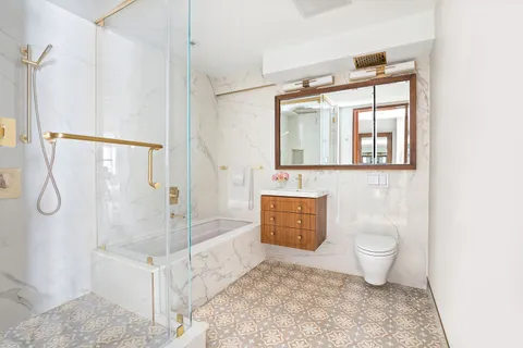 a bathroom with a granite countertop sink toilet and shower