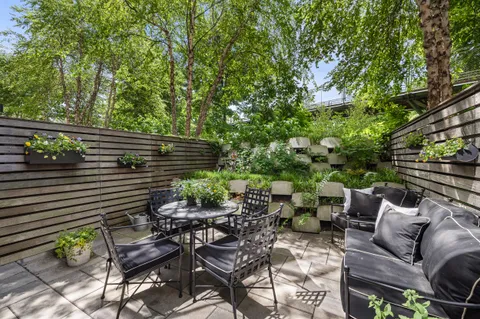 a view of a chairs and table in the back yard of the house