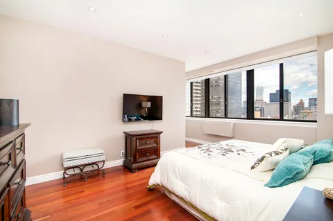 a bedroom with a bed and a flat screen tv