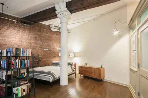 a bedroom with furniture and a book shelf