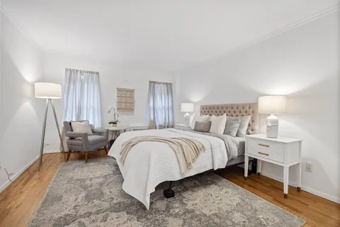 a spacious bedroom with a bed and a lamp