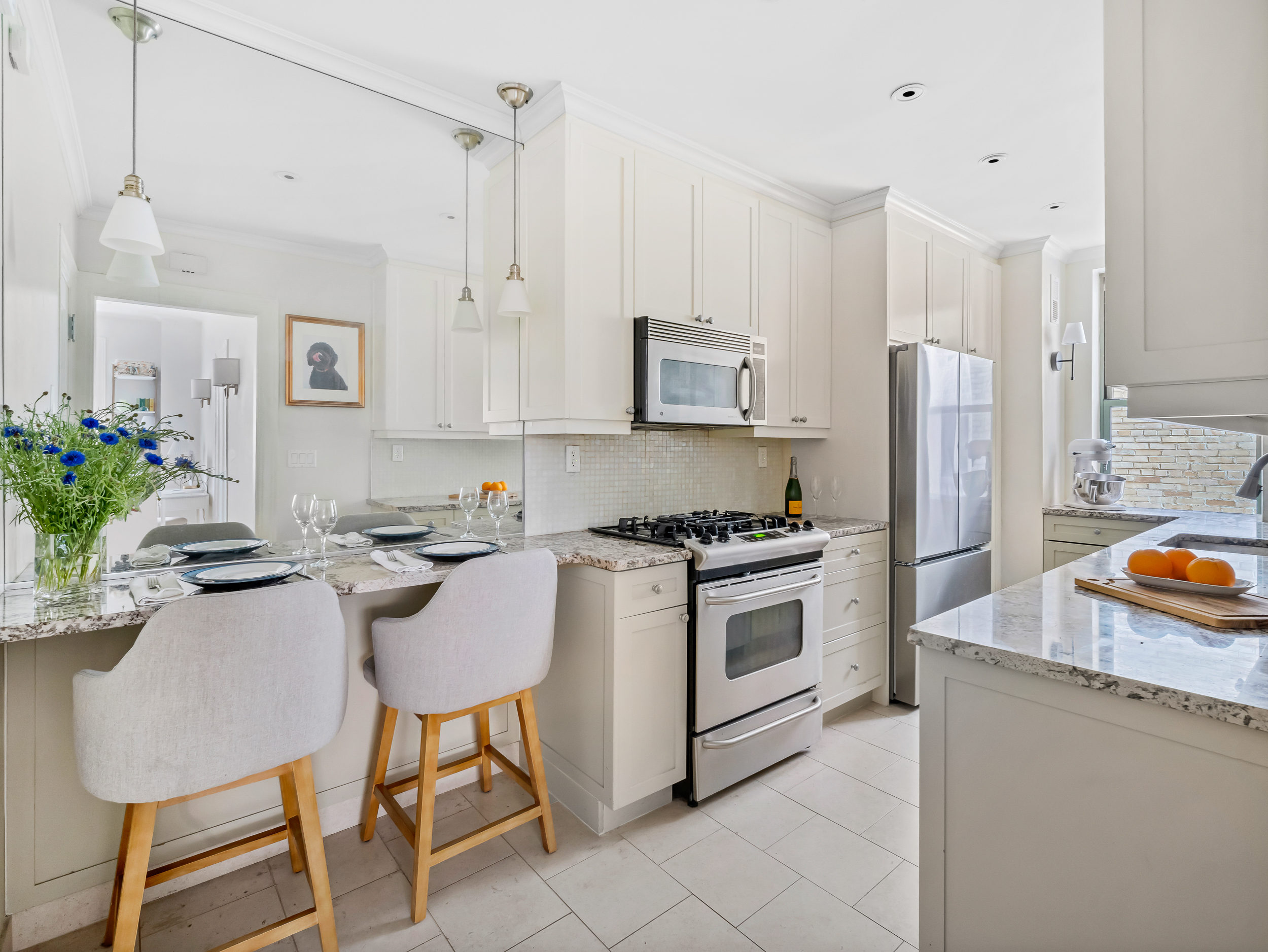 595 West End Avenue, Unit 3C Manhattan, NY 10024 - Photo 3 of 9 a kitchen with stainless steel appliances granite countertop a stove a refrigerator and a white cabinets