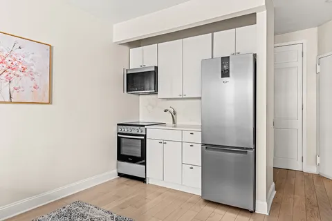 a kitchen with stainless steel appliances a refrigerator sink and microwave