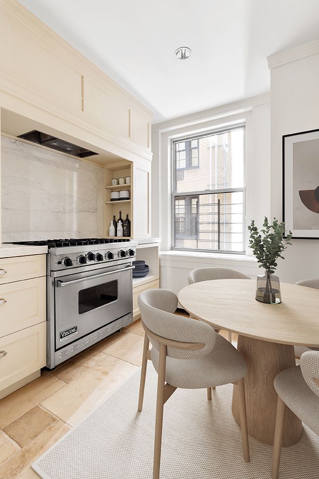 a kitchen with a stove cabinets and chairs