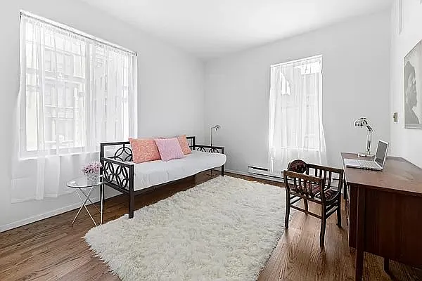 604 Riverside Drive, Unit 4E Manhattan, NY 10031 - Photo 3 of 8 a bedroom with a bed and a table in it with wooden floor