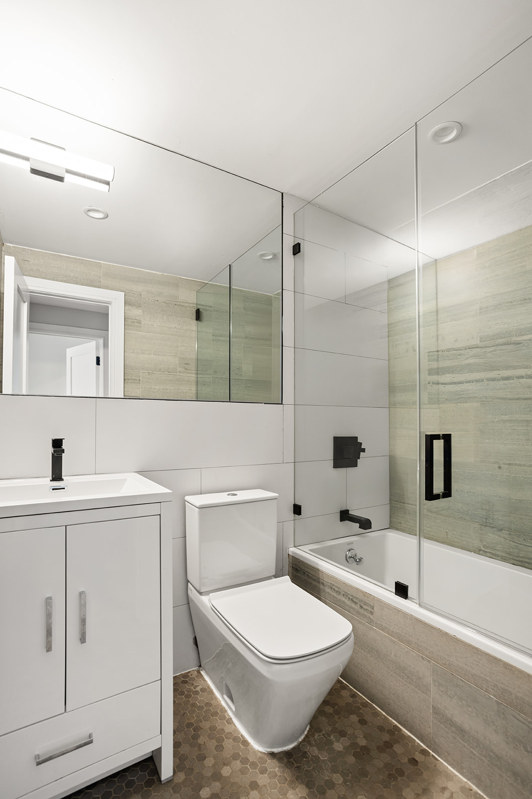 1183 Jefferson Avenue, Unit 1 Brooklyn, NY 11221 - Photo 8 of 11 a bathroom with a toilet a sink a mirror and shower