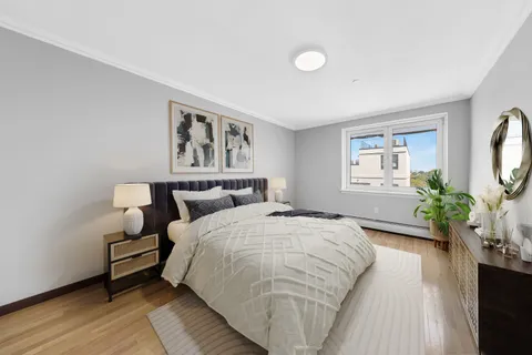 a spacious bedroom with a large bed and a potted plant
