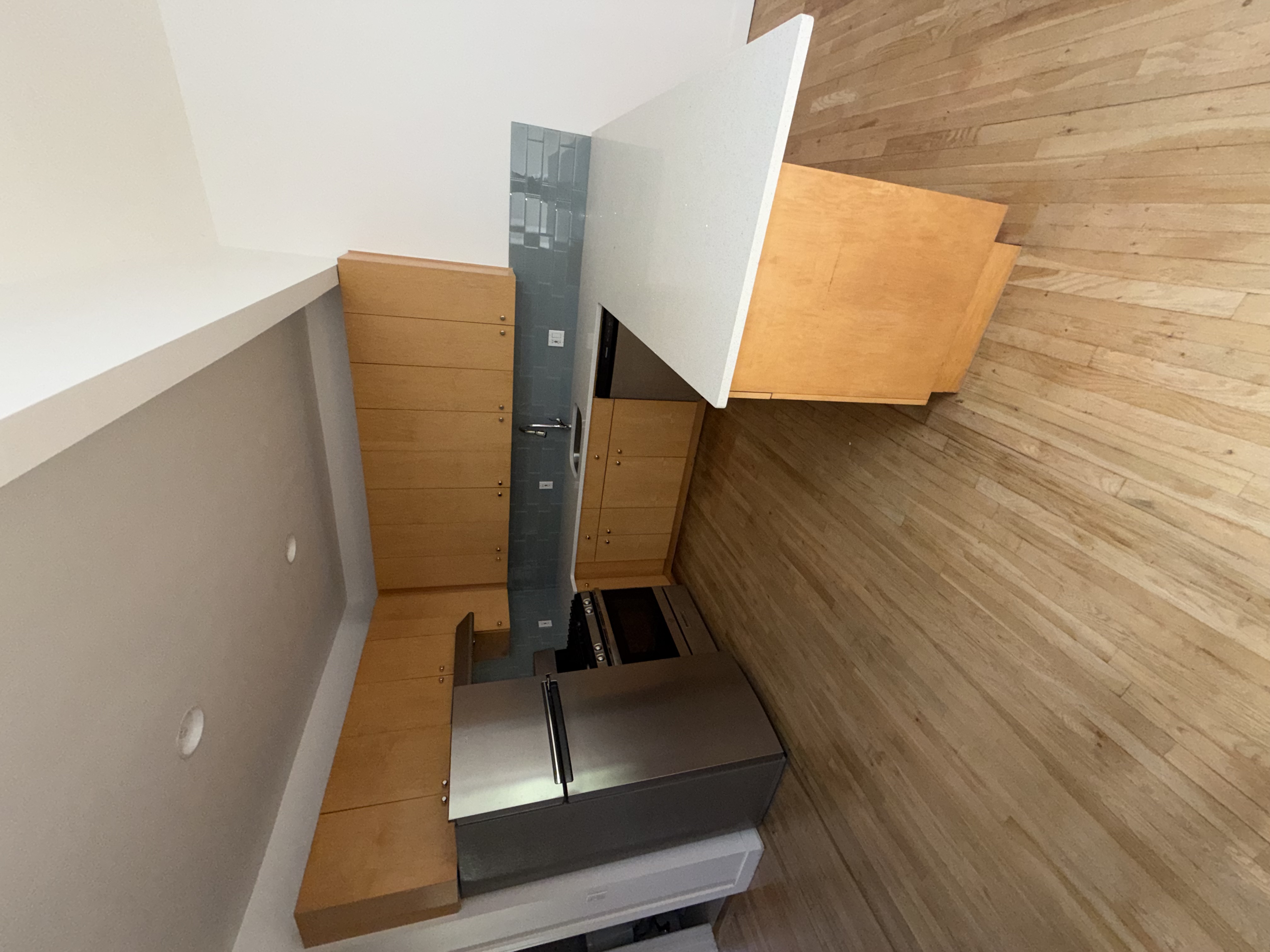 23 West 127th Street, Unit 3 Manhattan, NY 10027 - Photo 4 of 11 a kitchen with stainless steel appliances wooden floors and wooden cabinets