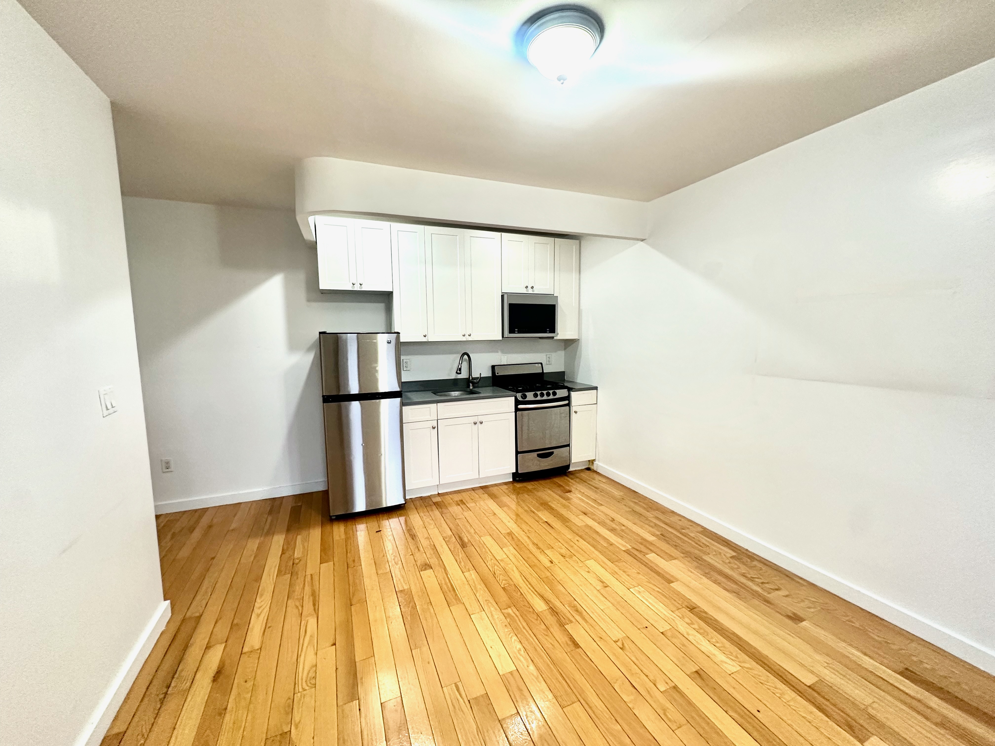 517 West 161st Street, Unit 32 Manhattan, NY 10032 - Photo 2 of 5 a view of kitchen with wooden floor