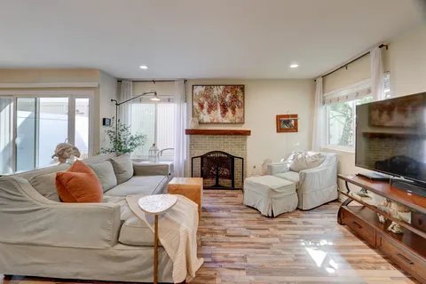 a living room with furniture a fireplace and a flat screen tv
