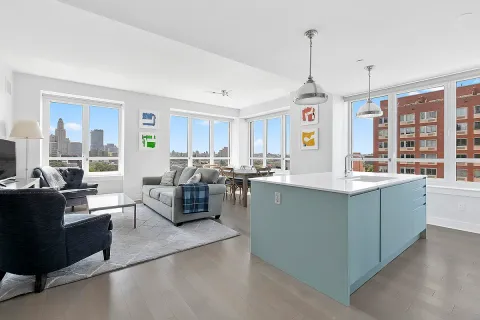 a living room with kitchen island furniture and a chandelier