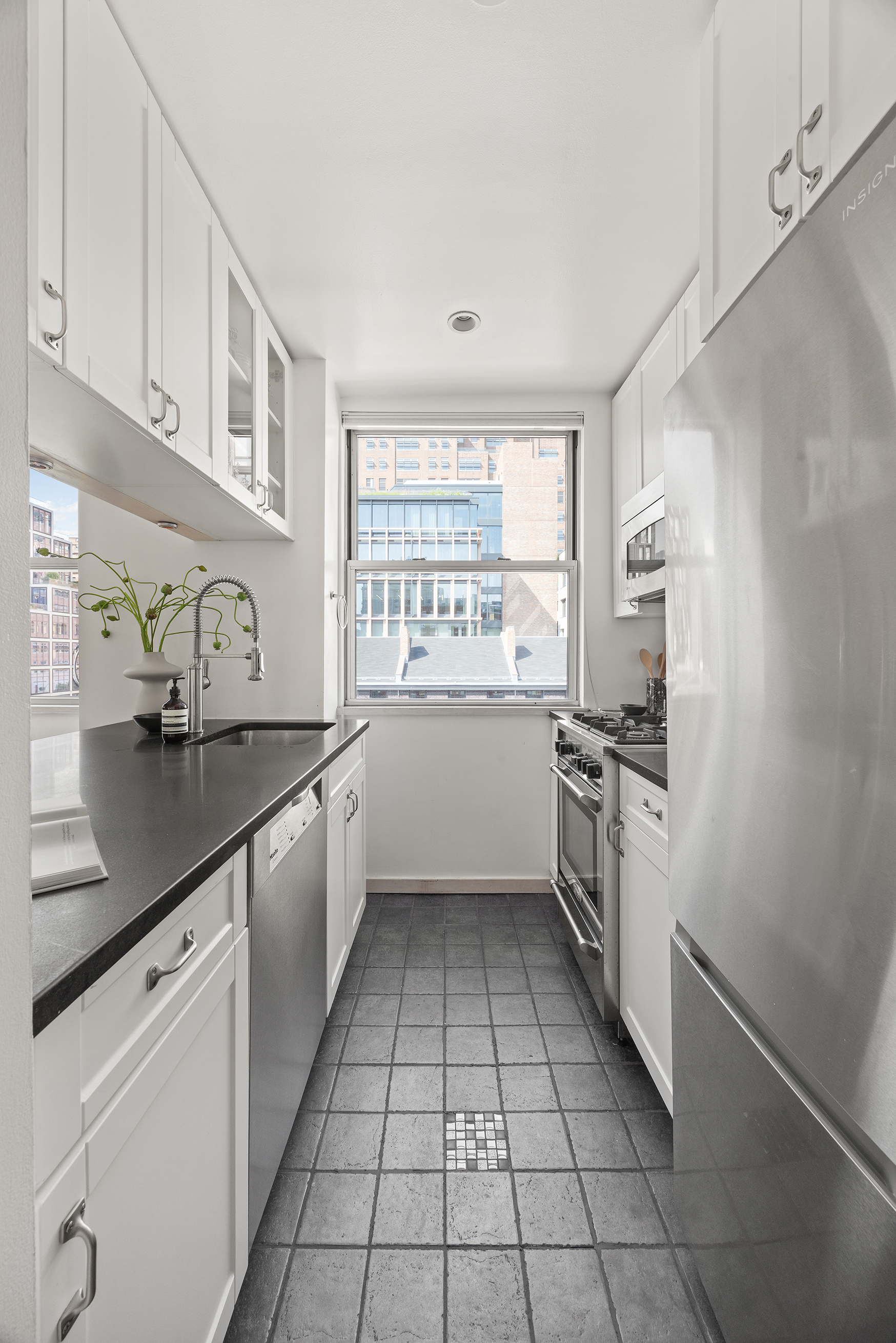 350 West 14th Street, Unit 6D Manhattan, NY 10014 - Photo 7 of 16 a kitchen with a sink a counter top space stainless steel appliances and cabinets
