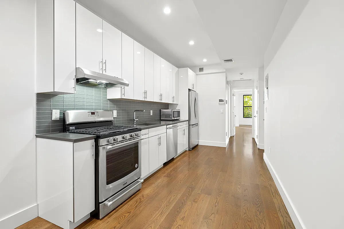 340 14th Street, Unit 2L Brooklyn, NY 11215 - Photo 3 of 9 a kitchen with stainless steel appliances granite countertop a stove top oven a sink and white cabinets