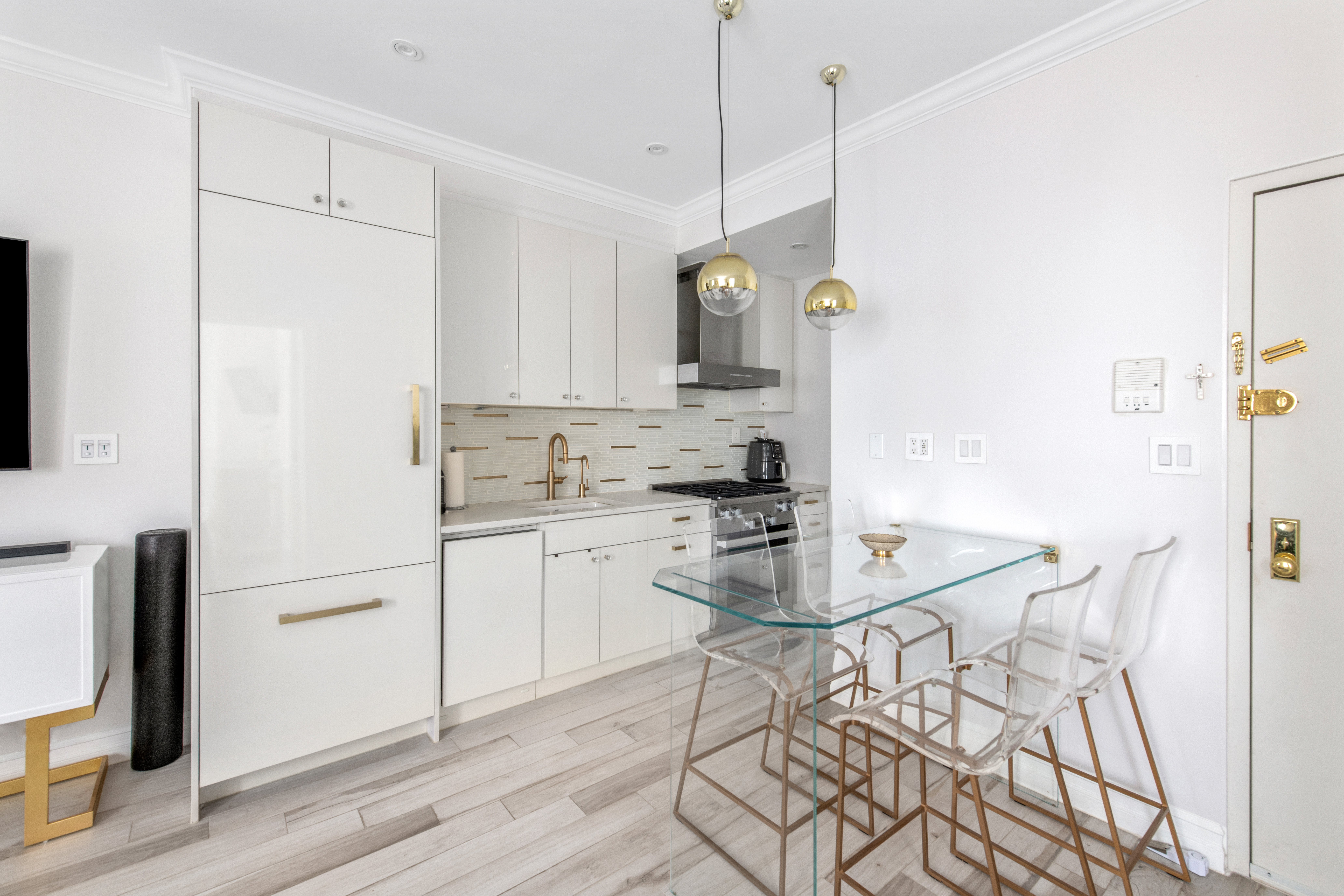135 Ridge Street, Unit 5A Manhattan, NY 10002 - Photo 1 of 11 a kitchen with a refrigerator a stove a sink and white cabinets with wooden floor
