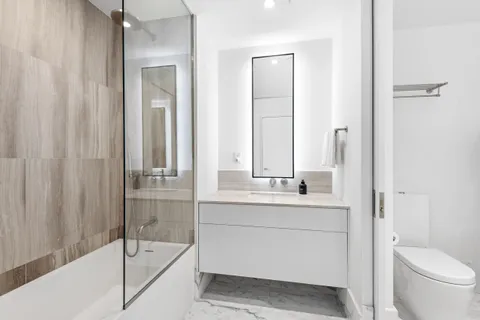 a bathroom with a sink a toilet and shower