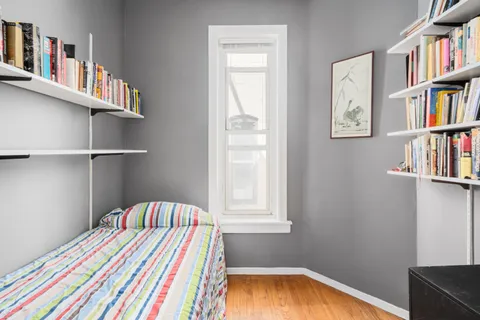 a bedroom with a bed and a book shelf