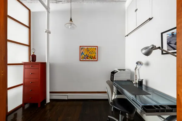 a view of a workspace with furniture and a window