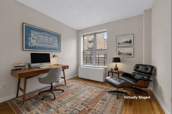 a view of a workspace with furniture and a window