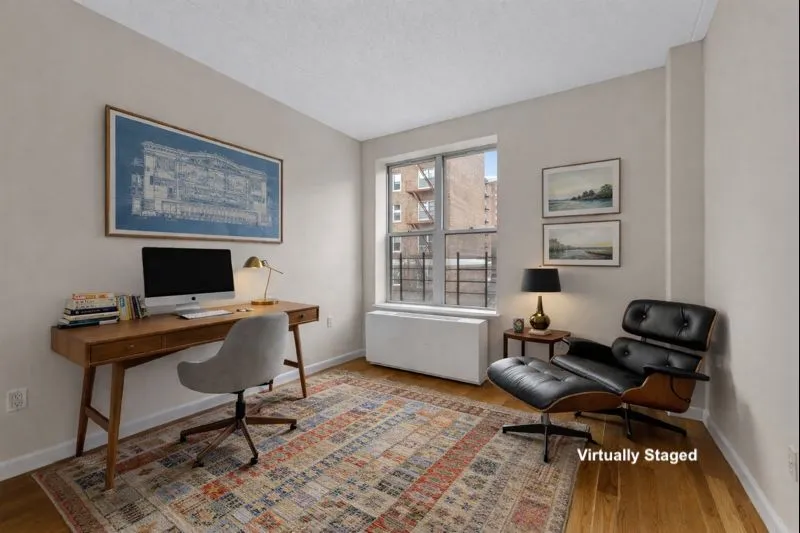 a view of a workspace with furniture and a window