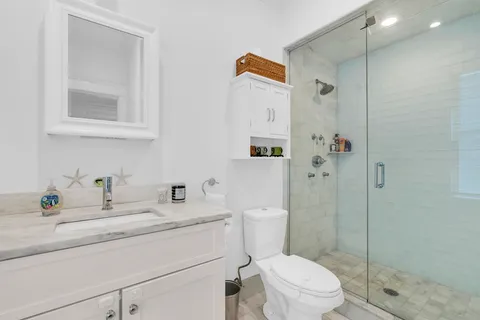 a bathroom with a sink toilet vanity and shower