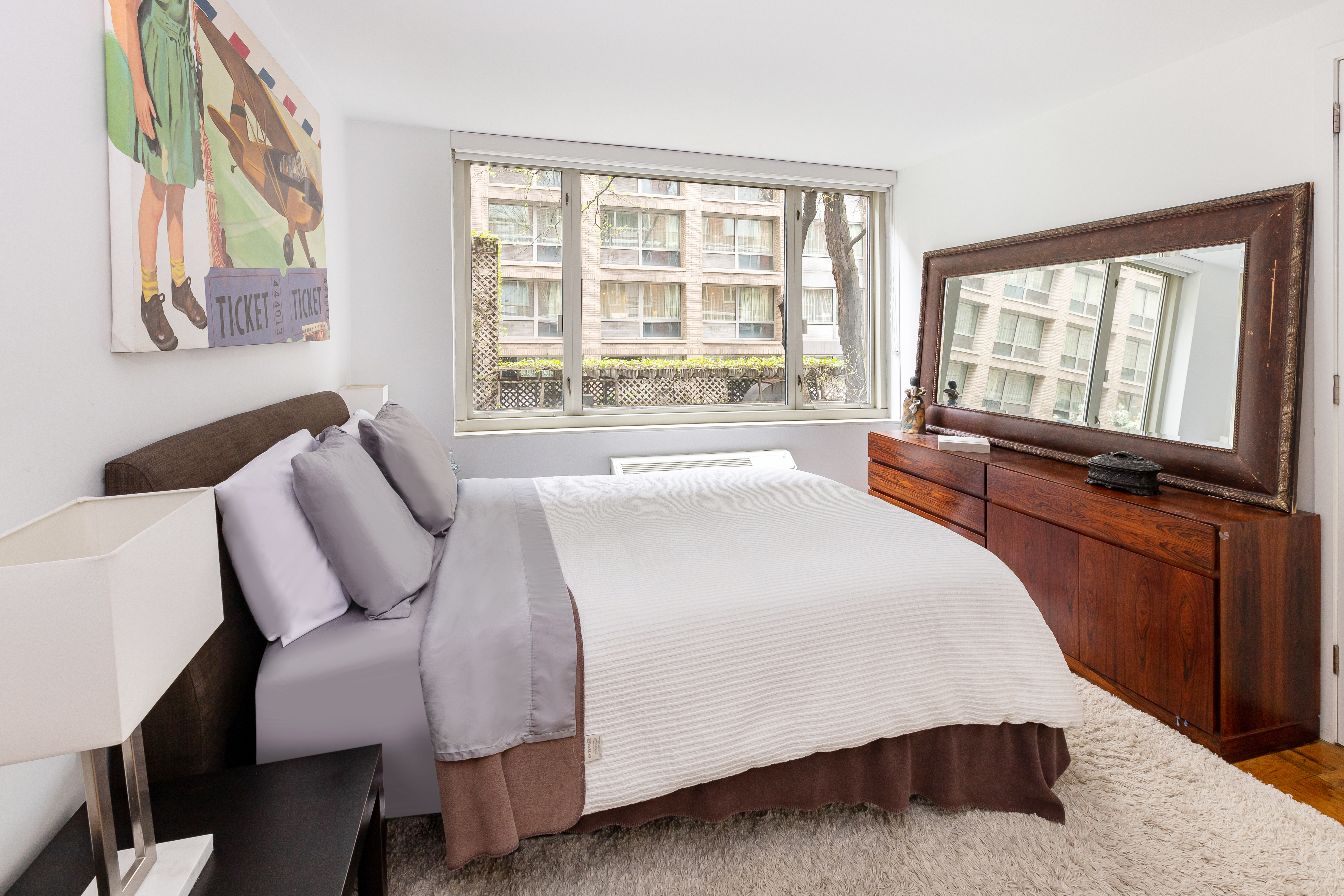 130 West 67th Street, Unit 2E Manhattan, NY 10023 - Photo 4 of 11 a bedroom with a large bed and a large window