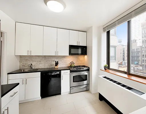 280 Park Avenue South, Unit 7A Manhattan, NY 10010 - Photo 4 of 13 a kitchen with granite countertop white cabinets and white appliances