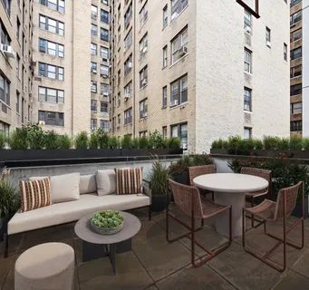 a view of a patio with couches table and chairs and potted plants