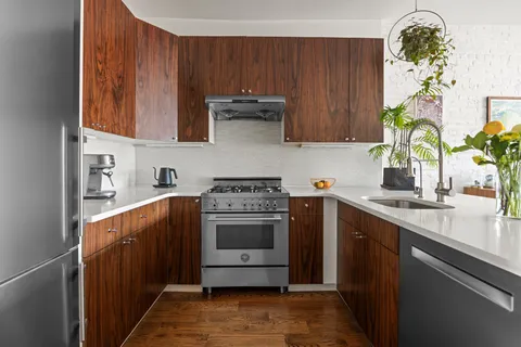 a kitchen with stainless steel appliances granite countertop a sink a stove and a microwave oven